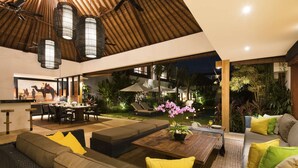 A modern outdoor living area with a dining setup, a sofa, and a coffee table. - Bali Villa Near the Beach, 2061 (Seminyak)