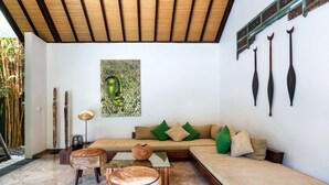 A modern living room with a sofa, ottomans, a painting, and decorative items. - Beautiful Villa With Private Pool, Bali Villa 2026 (Seminyak)