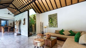 A spacious living area with a high ceiling, a sofa with green cushions, a coffee table, and a dining area with chairs and a table. - Beautiful Villa With Private Pool, Bali Villa 2026 (Seminyak)