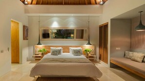 A modern bedroom with a large bed, a sofa, a TV, and a wooden ceiling. - Imagine Your Family Renting a Luxury Holiday Villa Close to Seminyaks Main Attractions, Villa Bali 2043 (Seminyak)