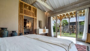 Een slaapkamer met een groot bed, een houten garderobe en uitzicht op het landschap.