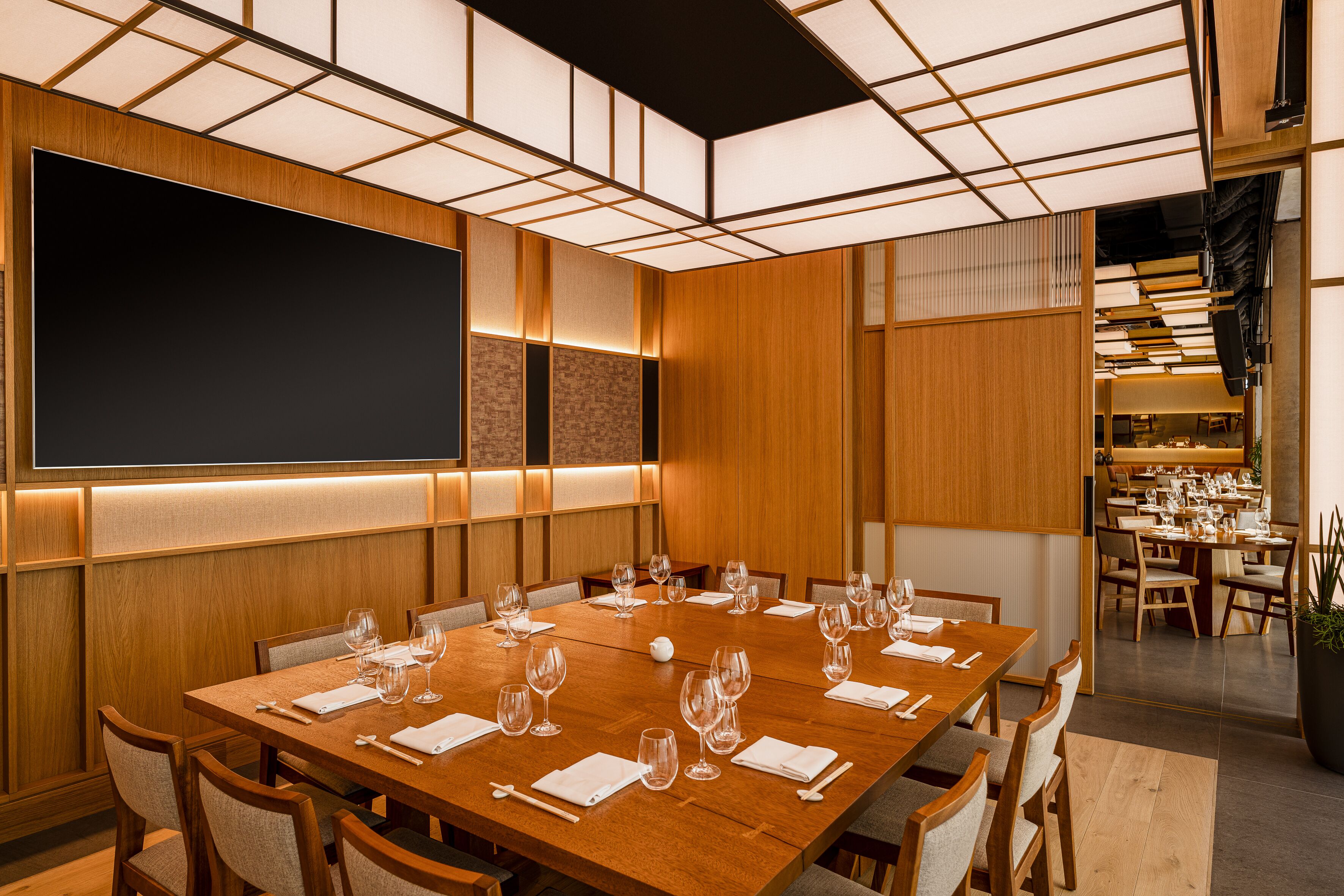 Une salle de conférence dotée d’une grande table dressée pour un repas, de lambris en bois et d’un tableau noir au mur.
