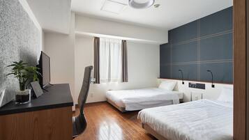 A hotel room with two single beds, a desk with a computer, a chair, a potted plant, and a large window with curtains.