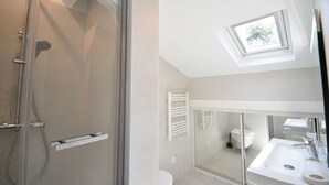 A modern bathroom with a glass shower enclosure, a skylight, and a white sink. - Hossegor “Côte d’Argent”, Apartment on the edge of the lake for 2 people. (HOSSEGOR)