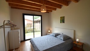 Een slaapkamer met een bed, nachtkastje en hanglamp.