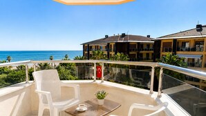 A balcony with a table, two chairs, and a potted plant. - Yaman Life Hotel (Alanya)