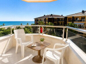 A balcony with a table, two chairs, and a potted plant. - Yaman Life Hotel (Alanya)