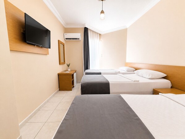 A hotel room with a flat-screen TV, an air conditioning unit, a desk with a mirror, two beds, and a bedside table. - Yaman Life Hotel (Alanya)