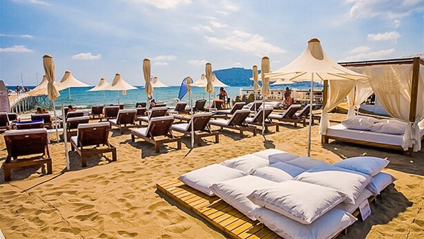 A beach with sun loungers and a canopy bed. - Yaman Life Hotel (Alanya)