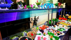 A buffet with various food items and a 'HOME' sign above it. - Yaman Life Hotel (Alanya)