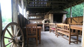 A rustic outdoor dining area with wooden furniture and a large wheel. - Ethno Village Stara Lonja (Sisak)