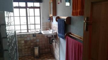 A small bathroom with a window, a sink, and a toilet.
