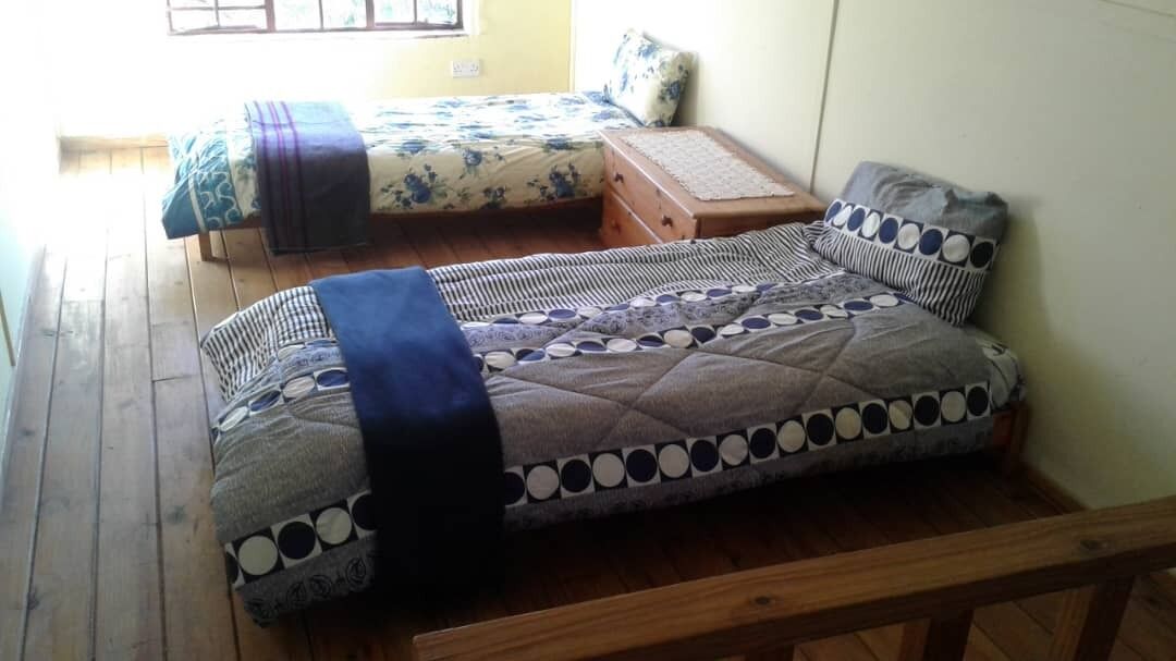 A room with a bed, a chest of drawers, and a small table.
