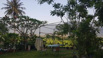 Een tuin met een tafel en stoelen, omringd door diverse planten en bomen.