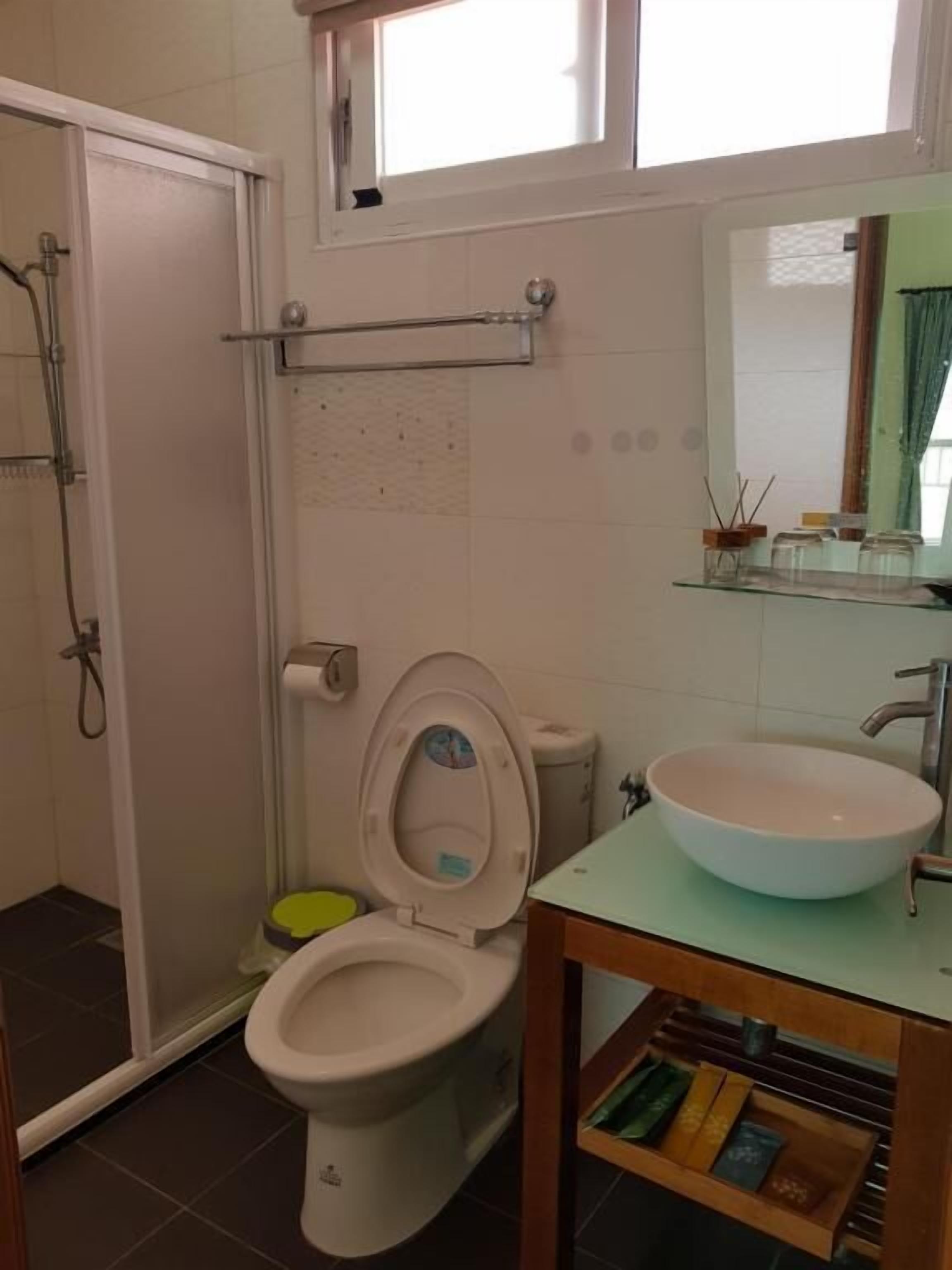 A bathroom with a toilet, a sink, and a shower.