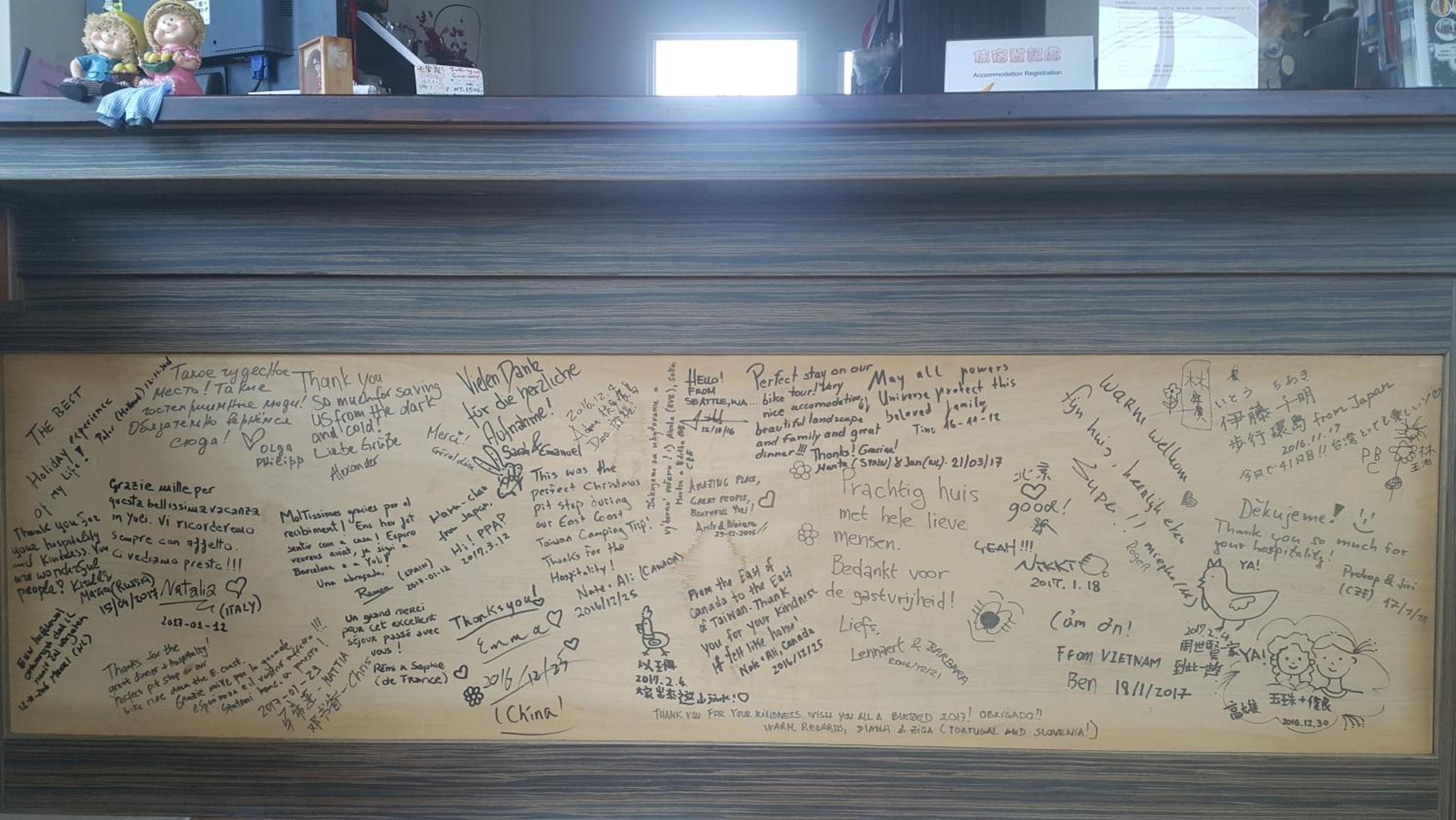 Eine Wand mit handschriftlichen Gästebotschaften in verschiedenen Sprachen.