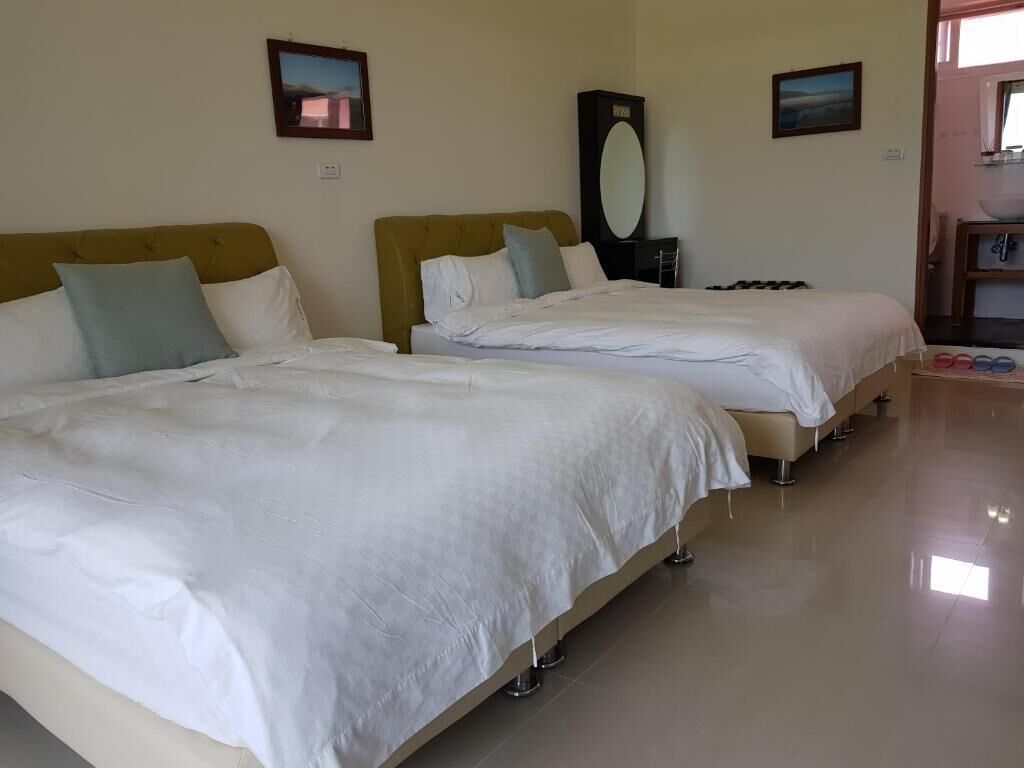 A hotel room with two beds, a large mirror, and a view of the outside.