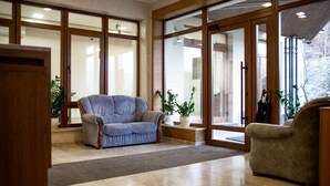 Un salón amplio con un gran ventanal, un sofá y un sillón.