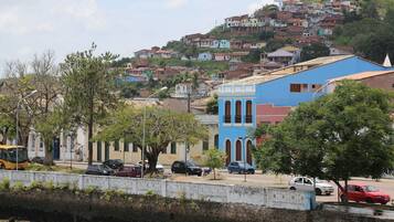 A hillside residential area with colorful houses, a blue building with arched windows, and a white building with a cross.