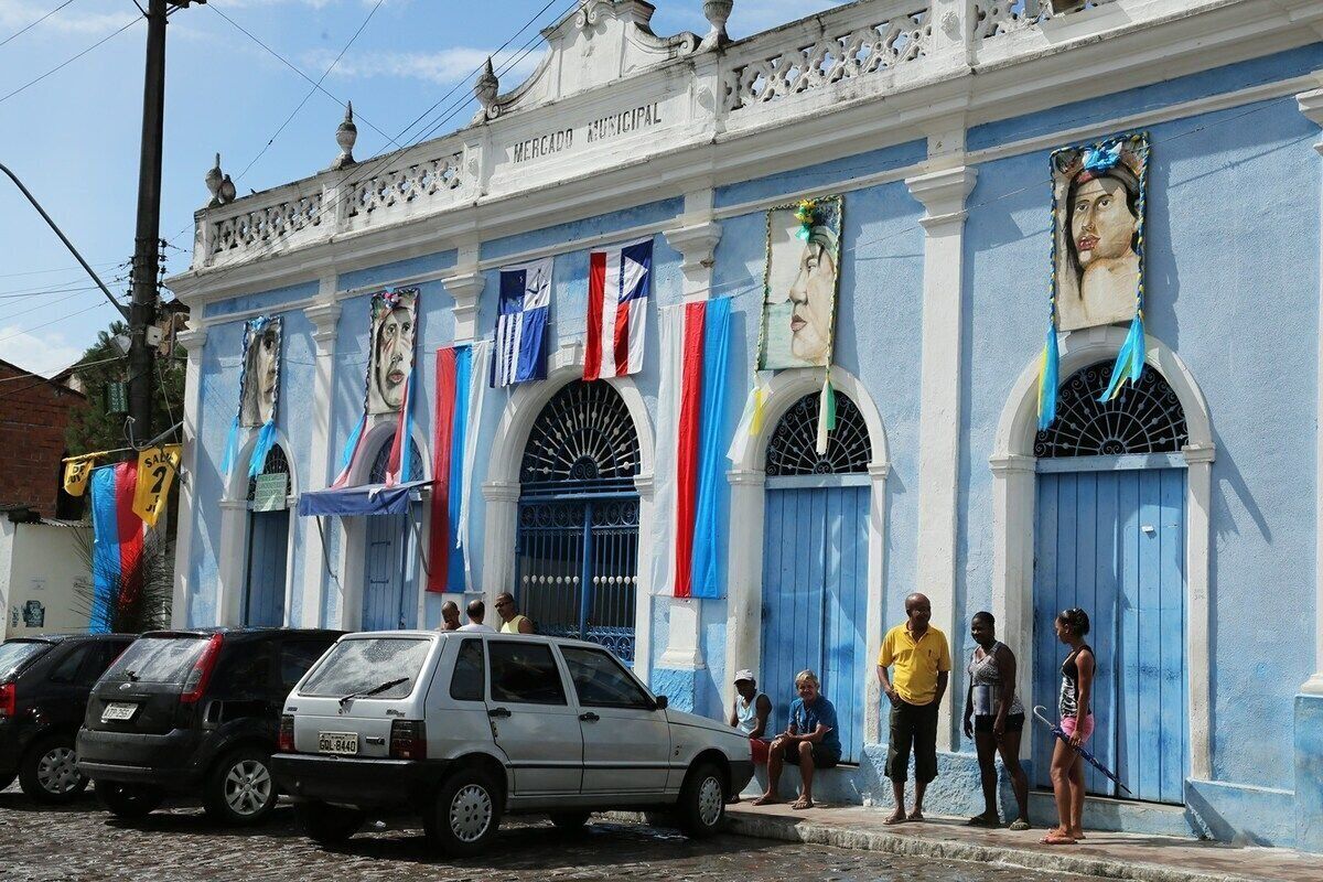 Un bâtiment à la façade bleue, doté de fenêtres en arc de cercle et de drapeaux.