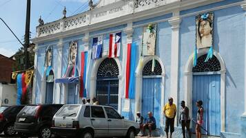 Un bâtiment à la façade bleue, doté de fenêtres en arc de cercle et de drapeaux.
