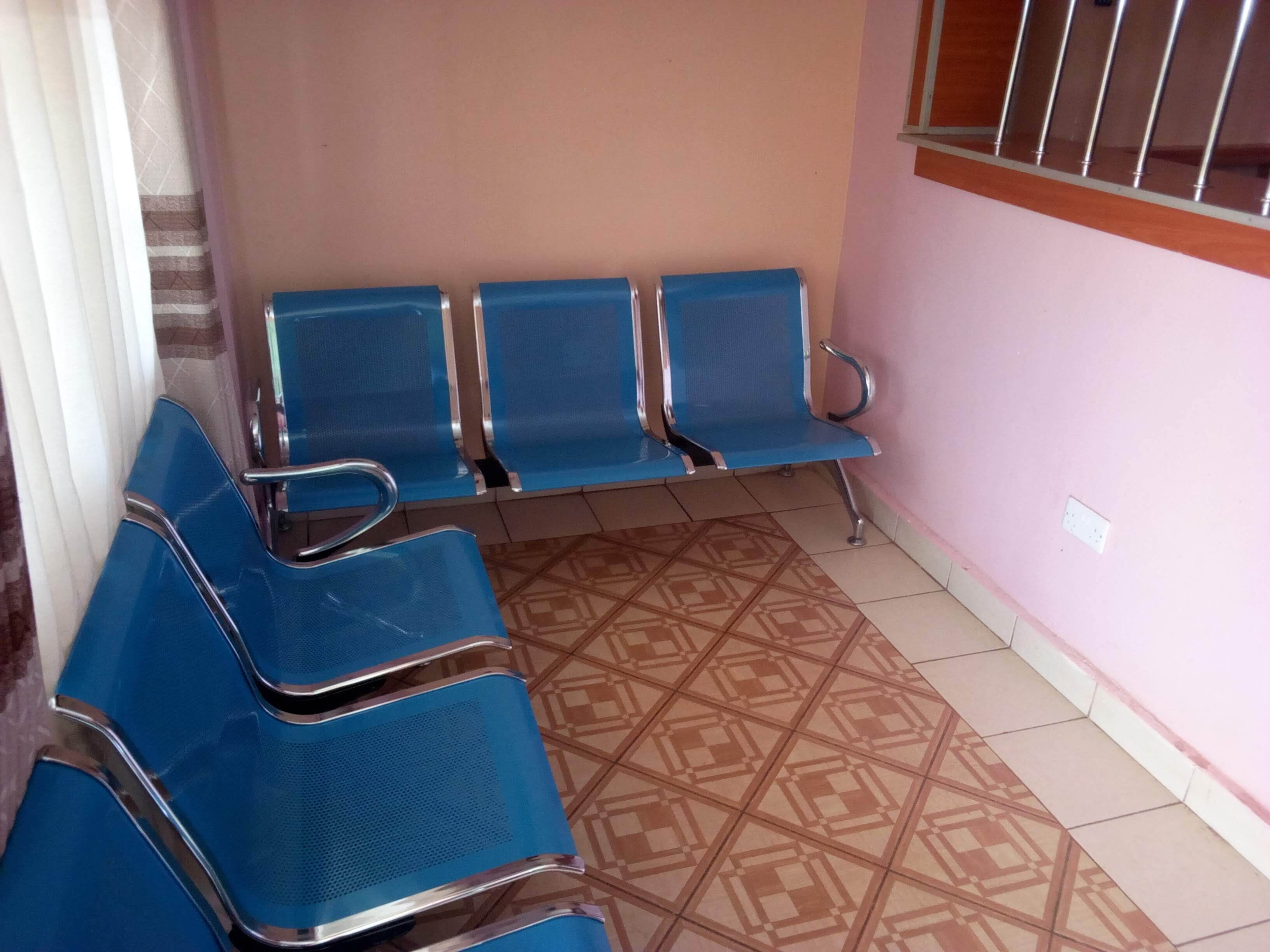 A waiting area with blue chairs and a patterned floor.