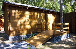 A wooden cabin with a stone foundation, a wooden deck, and a metal roof. - Pirineos Cien Lagos (Esterri D'Aneu)
