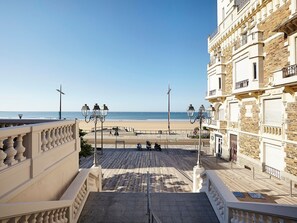 Una passeggiata lungomare con vista sulla spiaggia, un percorso pedonale e un edificio con balconi.