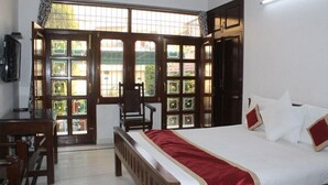Une chambre d’hôtel avec un lit, un bureau et une chaise.