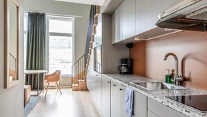A modern kitchen with a large window, a coffee maker, and a sink. - Part-Time Home Täby (Taby)