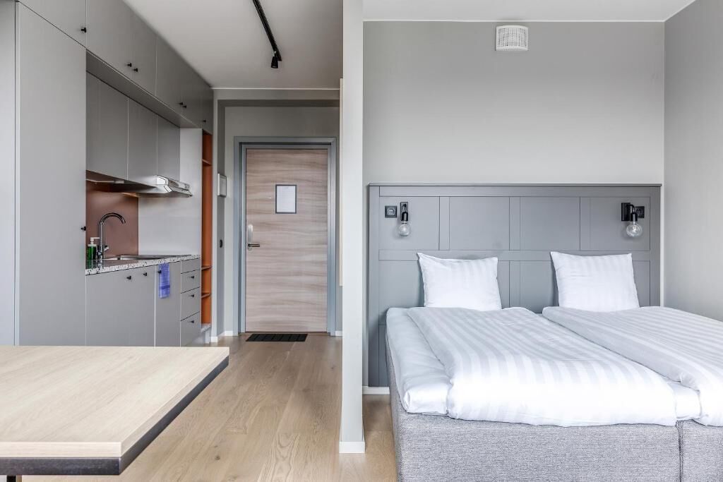Een moderne slaapkamer met een bed, nachtkastjes en een inbouwkast.