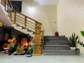 Un escalier avec une rampe en bois et une statue au sommet.
