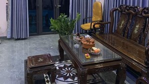 Un coin repas avec une table à plateau en verre, des chaises en bois et un tapis à motifs.