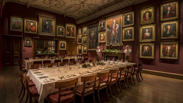 A formal dining room with a long table set for a meal, surrounded by framed portraits on the walls. - Thirlestane Castle (Lauder)