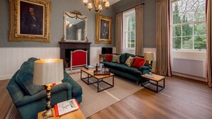 A living room with a fireplace, green sofa, and two armchairs. - Thirlestane Castle (Lauder)
