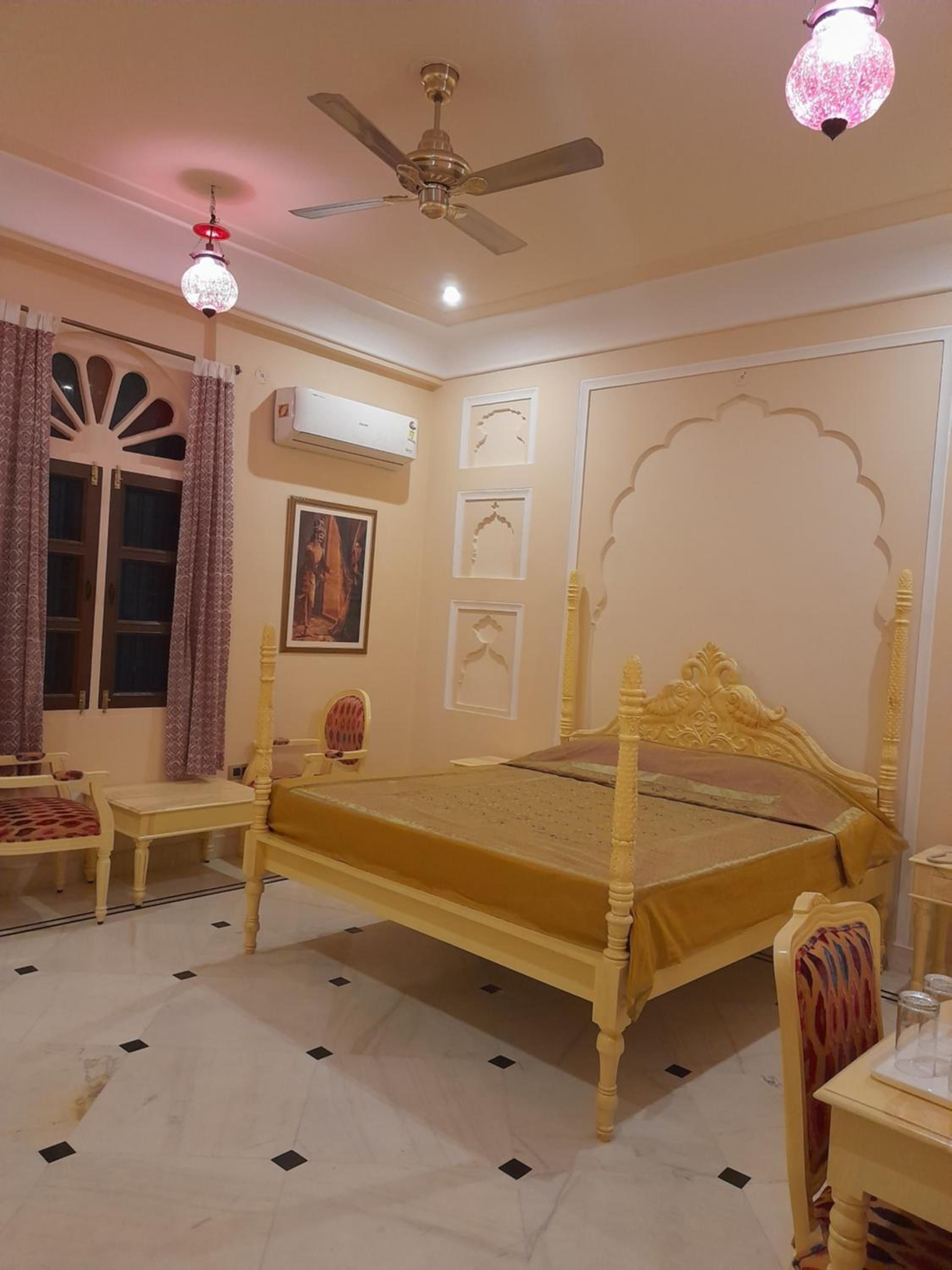A bedroom with a four-poster bed, a ceiling fan, an air conditioning unit, and a window with curtains.