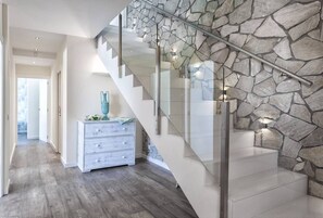 Staircase leads to an upper level with a dresser and decorative vase.