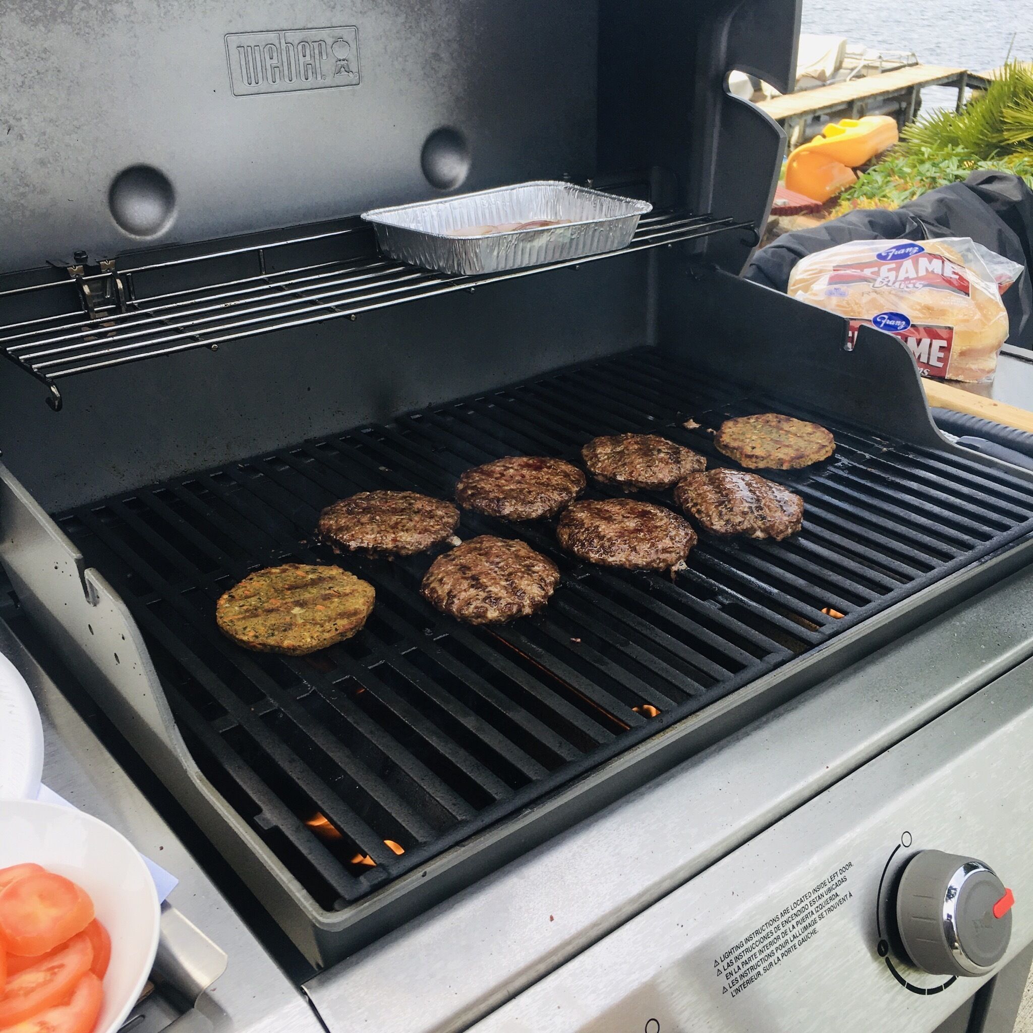 A grill with several burgers cooking.