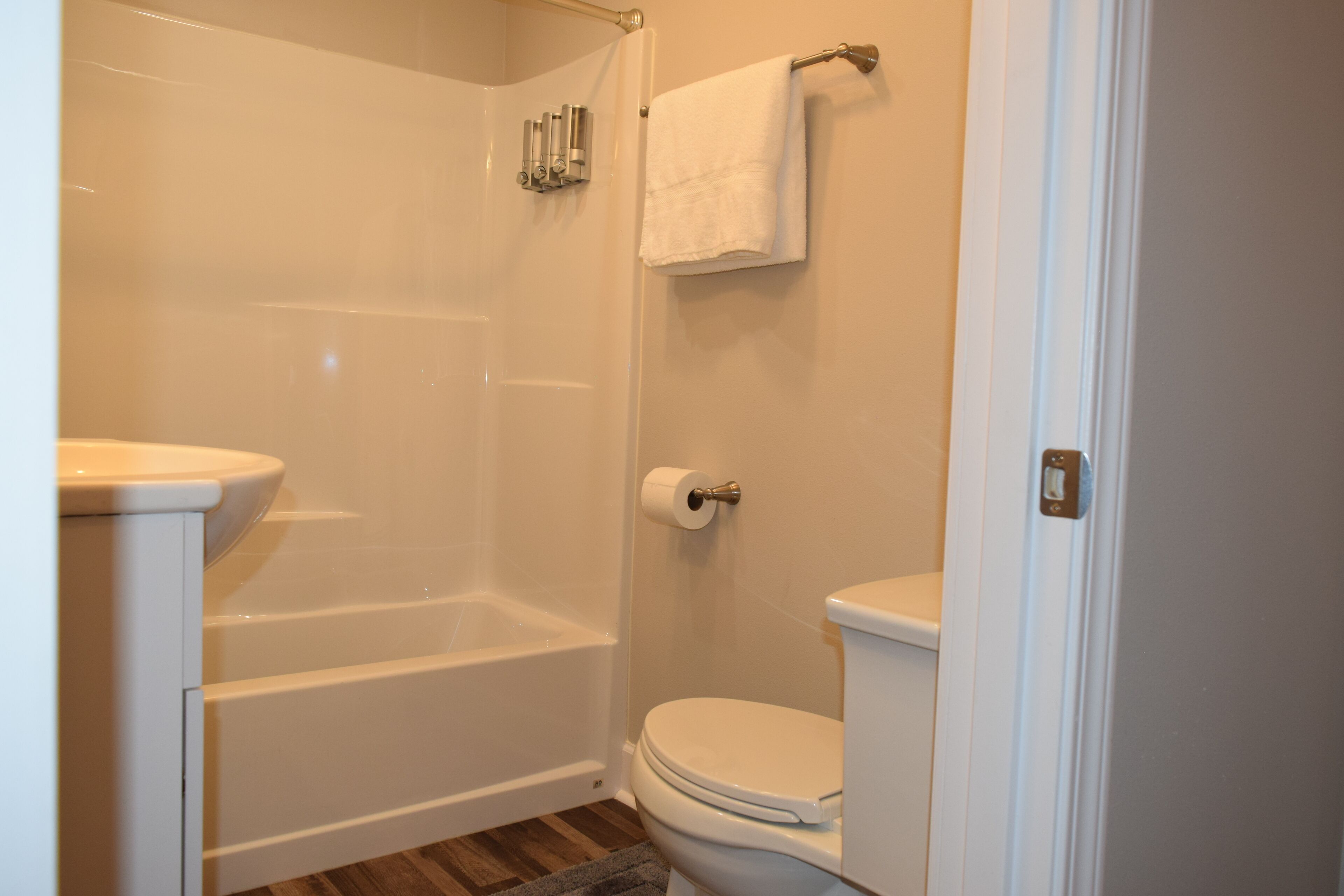 A bathroom with a bathtub, toilet, and a towel rack.