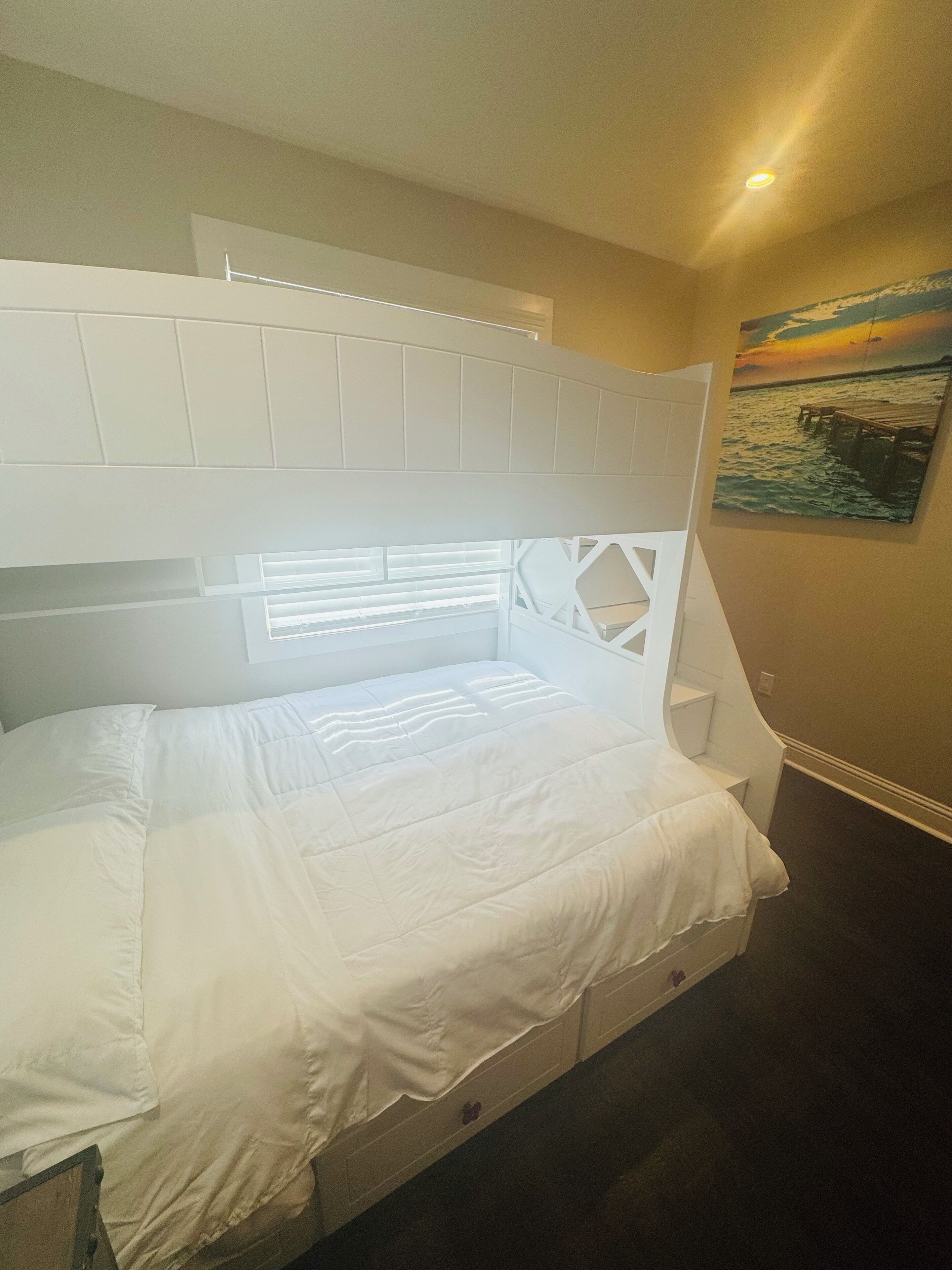 Une chambre à coucher avec un lit, une fenêtre et un tableau accroché au mur.