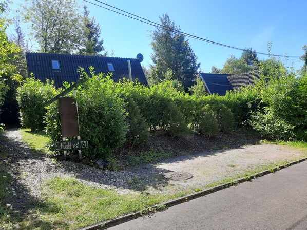 A residential property with a gravel driveway, a wooden sign, and a metal gate. - Idyllic Holiday Home in the Palatinate Forest (Gossersweiler-Stein)