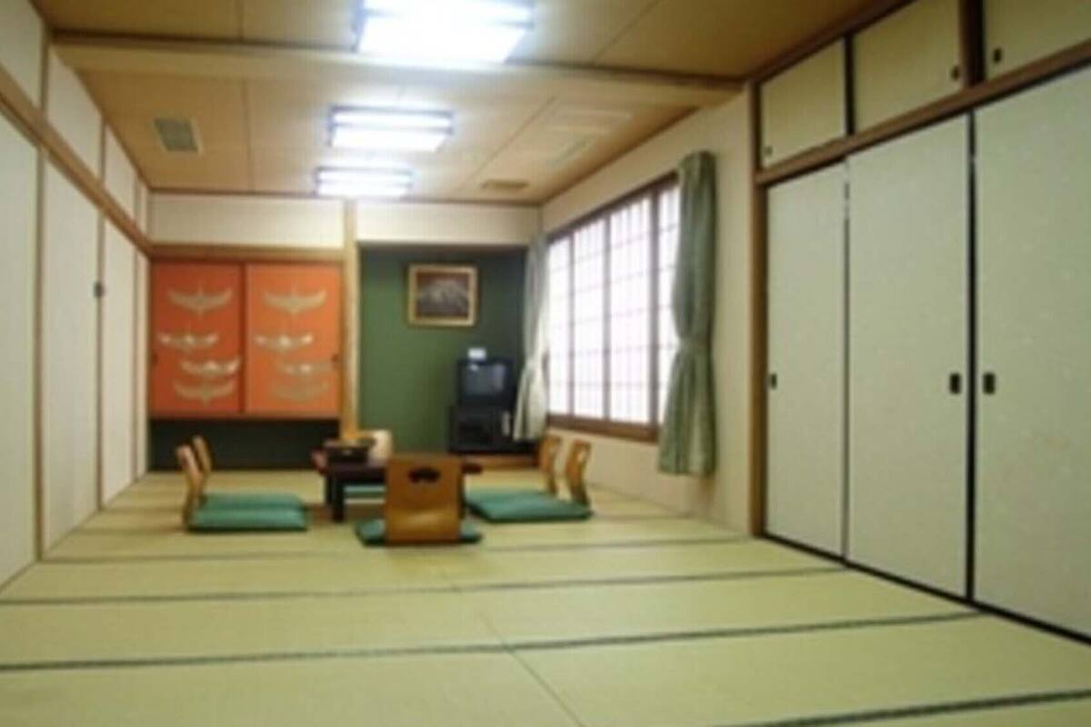 A tatami mat room with sliding doors, a low table, and cushions.