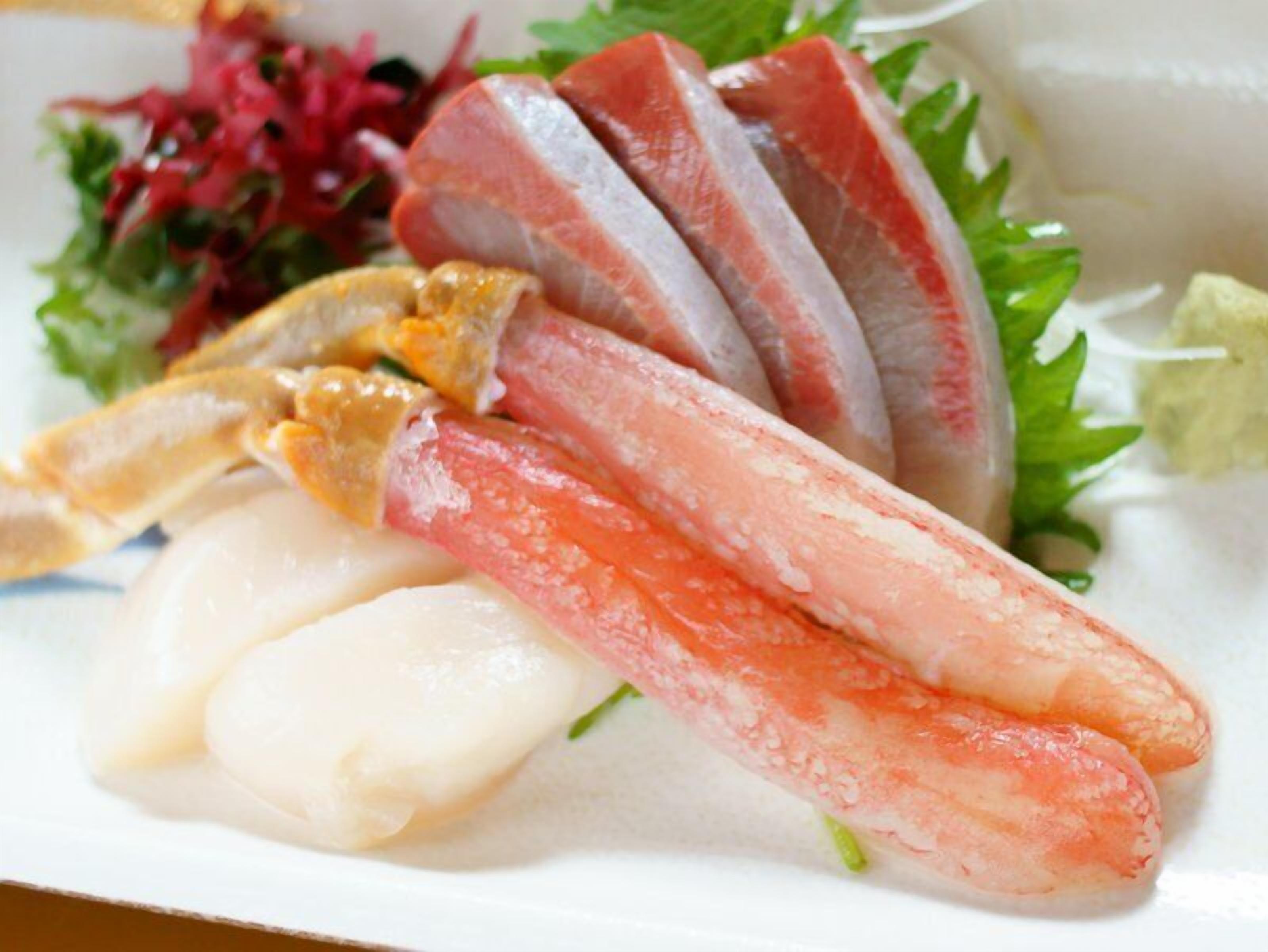 A plate with various seafood items, including fish and possibly crab legs, accompanied by a side salad.