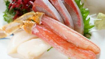 A plate with various seafood items, including fish and possibly crab legs, accompanied by a side salad.