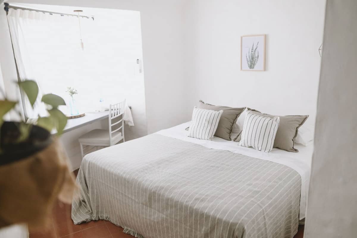 Ein Schlafzimmer mit Bett, Schreibtisch und Fenster.