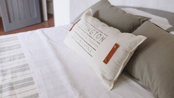 Una cama con un almohadón que tiene un logo y texto.