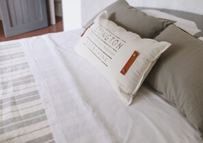 A bed with a pillow that has a logo and text.