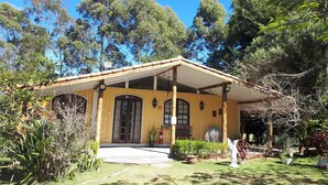 A yellow wooden building with a covered porch, large windows, and a fire extinguisher. - LEASE, EVENTS, TIROLESA, ARVORISMO, CRAFTSMAN, 360 ° VIEWPOINT (Guaratinguetá)