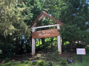A wooden sign with the text "sitio Mirante" indicating a viewpoint or scenic area.