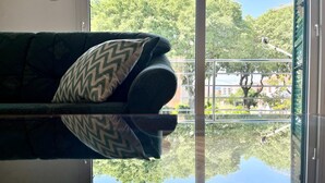A room with a sofa and a glass table reflecting the outside view. - Lemon Tree Apartments (Zadar)
